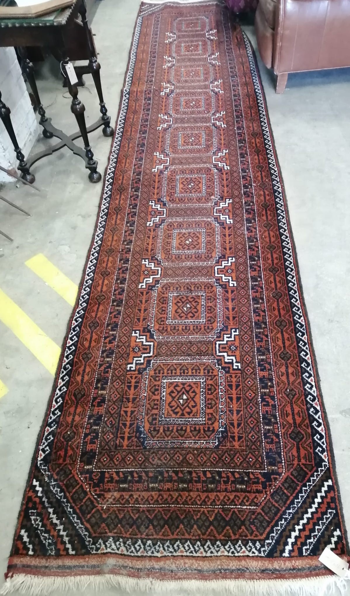 A Belouch red ground runner, approx. 400 x 84cm *Please note the sale commences at 9am.